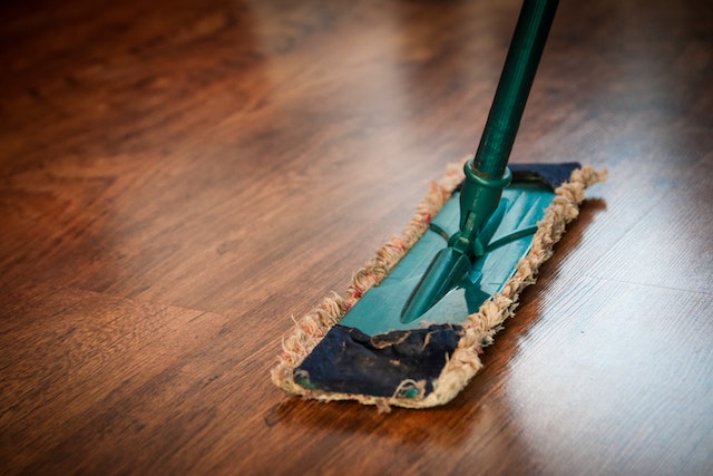 person cleaning wooden floors